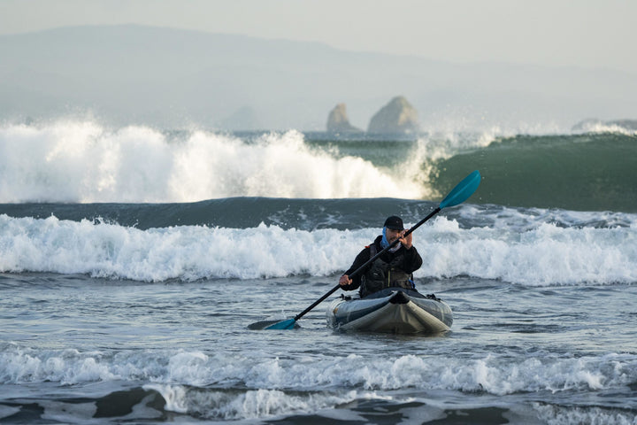 Solo angler kayaking on ocean waves in a Blackfoot Angler 130 kayak.