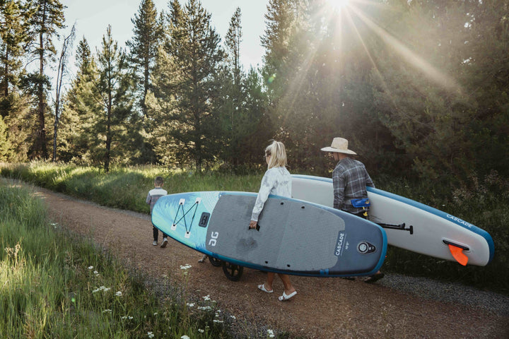 Family with Cascade 10 Paddleboard enjoys a sunlit forest stroll using lightweight designs.