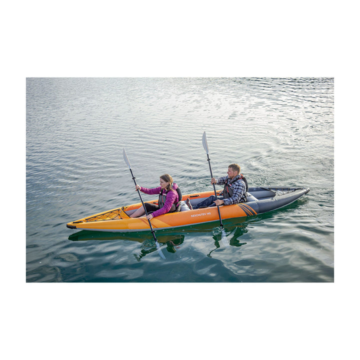 Two people exploring calm waters in a Deschutes 145 tandem touring kayak.